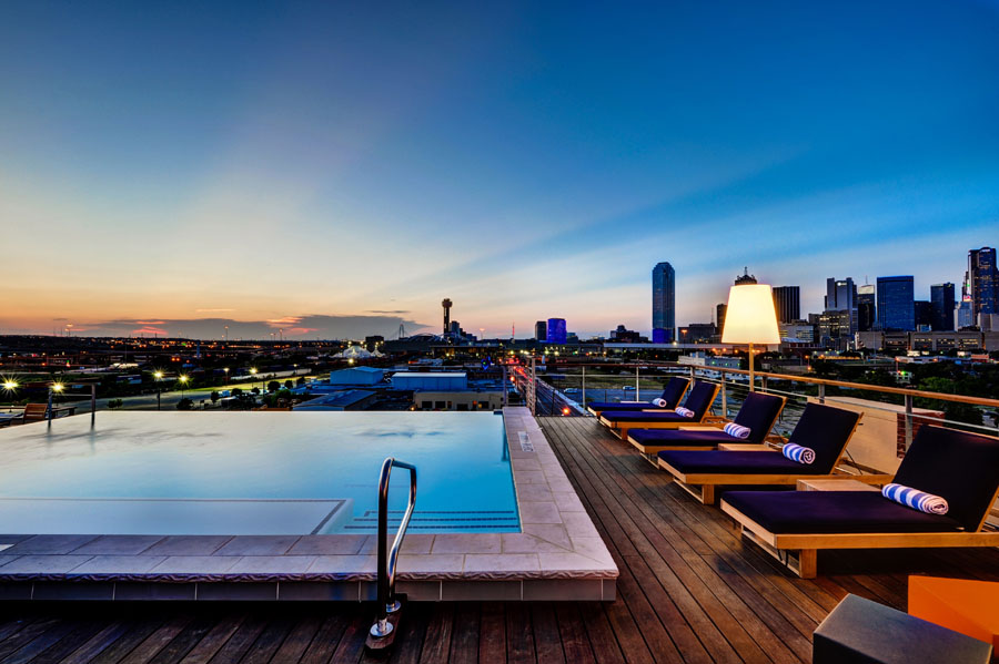 a pool on a rooftop with a city in the background